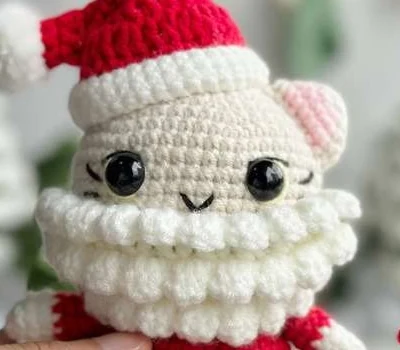 Nahaufnahme des gehäkelten Bobbel-Barts und Gesichts der Amigurumi-Santa-Katze
